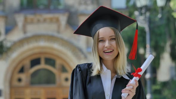 Graduand in Mantle Demonstrating Her Diploma