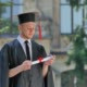 Graduand in Mantle Thinking Holding His Diploma - VideoHive Item for Sale