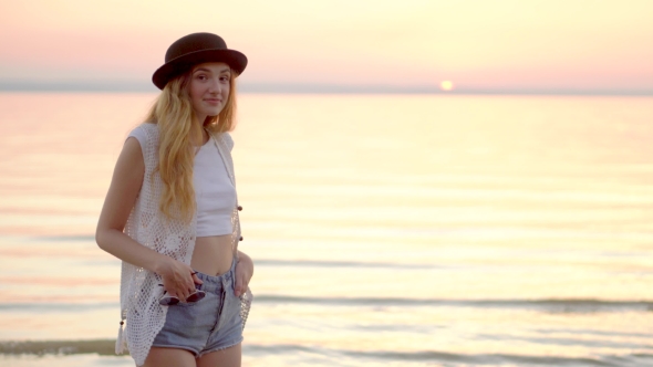 Pretty Young Girl In Hat Posing On The Background Of Ocean And Golden Sunset