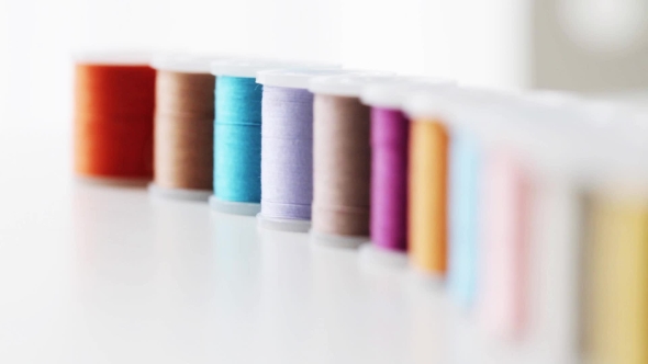 Row Of Colorful Thread Spools On Table 3