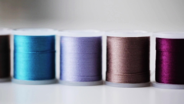 Row Of Colorful Thread Spools On Table 5