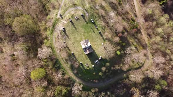 Drone Shot (facing down, rotating) of a Chapel surrounded by Tombstones on top of a Hill (2)