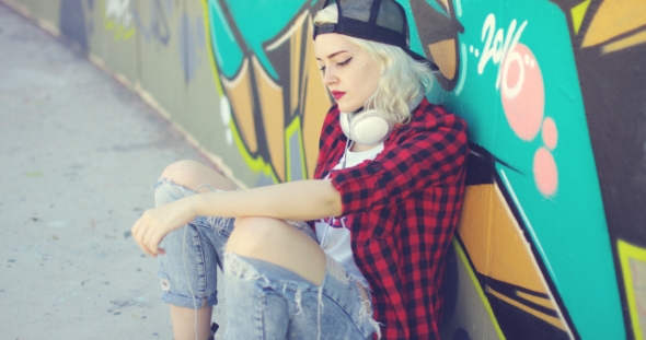 Trendy Young Urban Woman Waiting On Her Skateboard