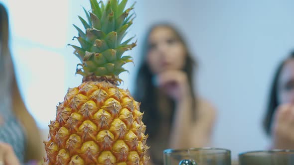 Pineapple with Green Top Against Blurred Calm Women