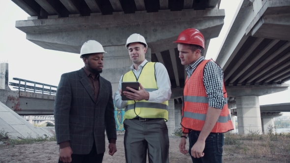 Three Architects Discussing Project Using Tablet
