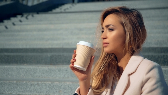 Businesswoman Sitting On Stairs Drinking Coffee And Thinking.
