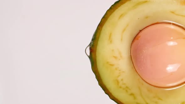 Macro Shot of Fresh Cut Avocado with Juice and Oil Stream on White Background