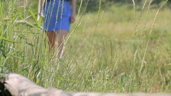 Girl Walking In The Park And Touches The Grass