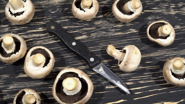 Mushrooms On a Wooden Board With a Knife.