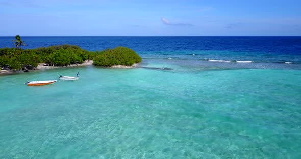 Tropical drone tourism shot of a white sand paradise beach and blue sea background in 4K