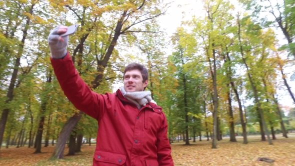Man With Smartphone Taking Video At Autumn Park