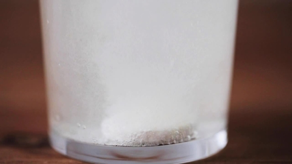 Effervescent Pill Dissolving In Glass Of Water