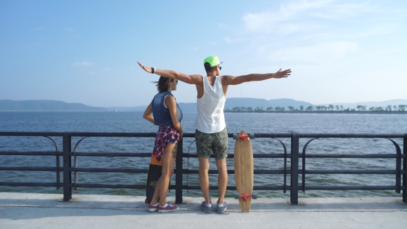 Couple In Love With Skateboards On The Promenade Down The Stairs