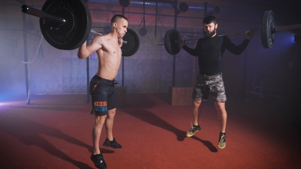 Two Strong Man Doing Weightlifting Training Together At The Gym.