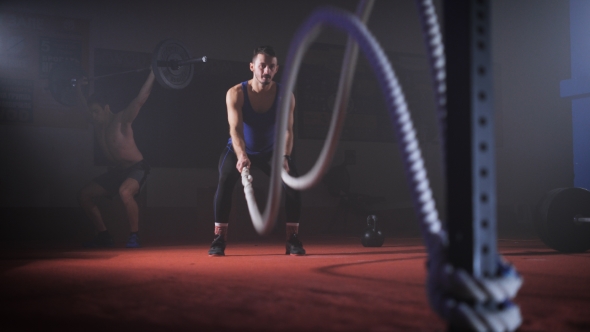 Fit Young Man Holds Rope In His Hands And Makes Heavy Rope Training Workout.