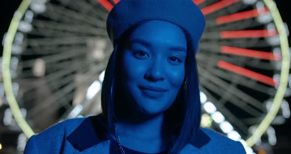 Close Up View of Young Attractive Woman Looking To Camera While Standing in Neon Lighting at Street