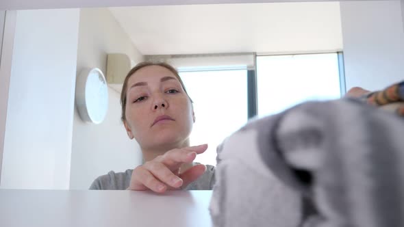 Young Woman Is Putting Clothes in Wardrobe Cleaning in Her Home.