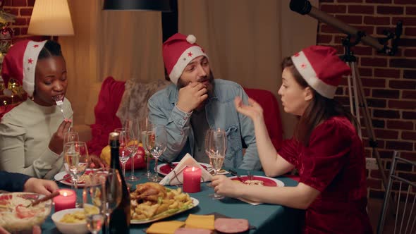 Festive People Talking at Christmas Dinner While Enjoying Traditional Home Cooked Food