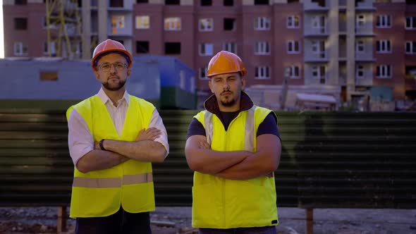 Two Builders Stand and Crosses Their Hands