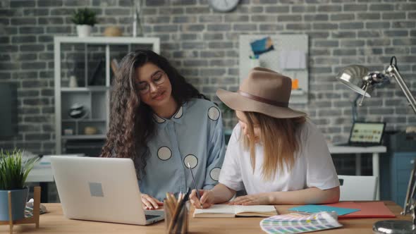 Creative Designers Writing in Notebook Then Working with Laptop in Office