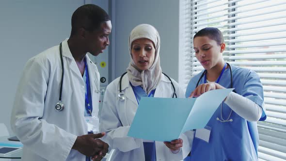 Front view of Multi-Ethnic doctors discussing over medical report in hospital