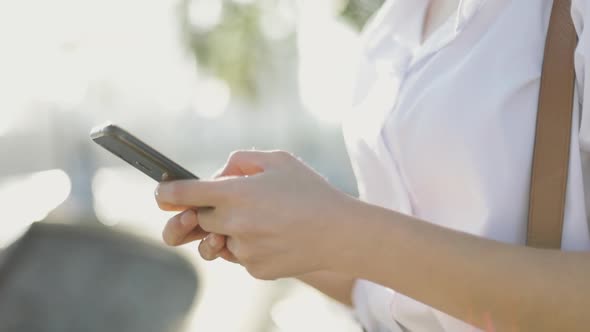 Close up Asian businesswoman in a white shirt is using a smartphone.