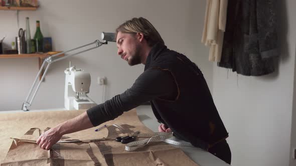 Handsome Male Tailor with Ruler Working in Sewing Workshop