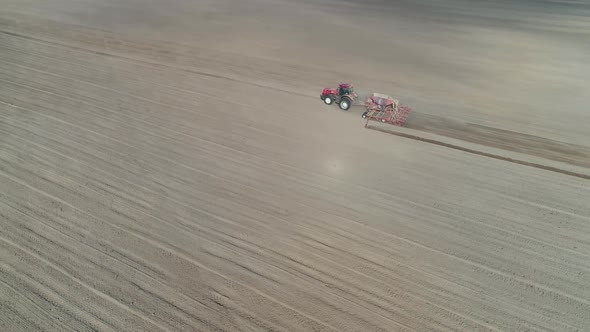 Countryside and Agriculture Farm Tractors Plow the Earth in Field Dust in the Field View From Height