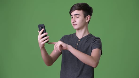 Young Handsome Iranian Teenage Boy Against Green Background