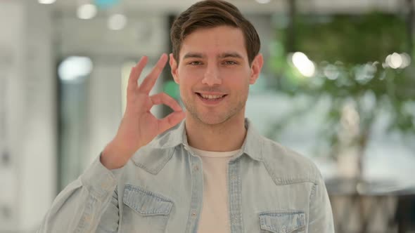 Portrait of Creative Young Man Showing Okay Sign with Hand