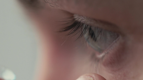 Young Handsome Man Putting Contact Lens In His Eye . alt