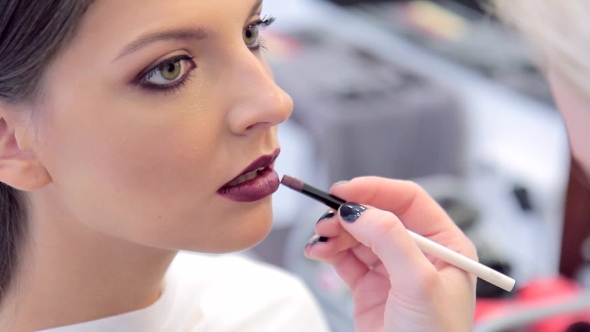Make-up Artist Applying The Lipstick To Model's Lips