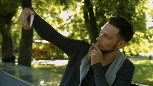 Young Man Makes a Selfie in the Park 01