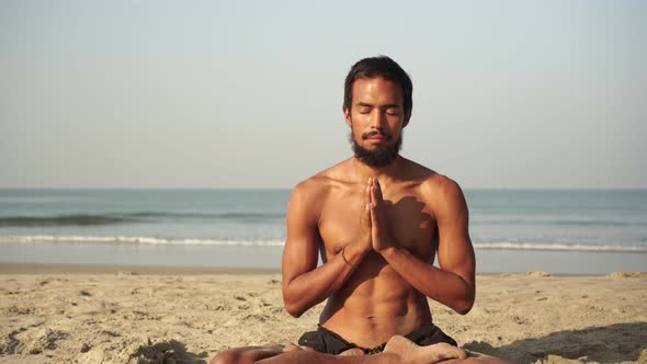 A Man Does Yoga and Meditation in the Lotus Position in Nature