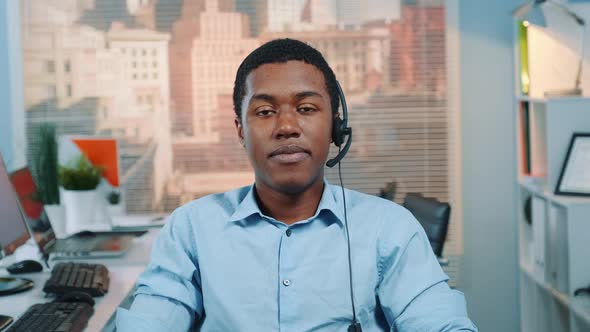 Portrait of Black Customer Service Operator in a Headset Smiling To the Camera