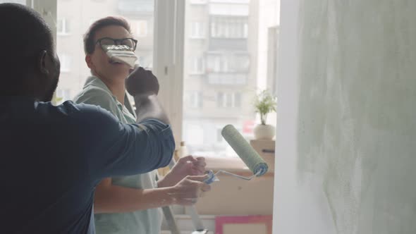 Positive Multiethnic Couple Painting Walls Together