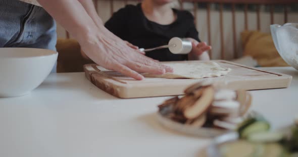 Mother and daughter making pizza at home