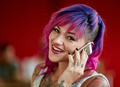 Confident female designer talking on a mobile phone in red creative office space - PhotoDune Item for Sale