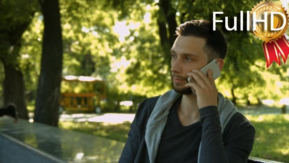 Young Man Speaks on the Phone in the Park 01