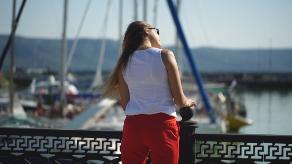 Beautiful Girl Straightens Her Hair On The Background Of Yachts