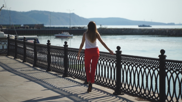 Beautiful Young Woman Walking On Pier