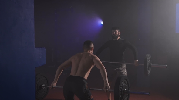 Two Athletes At The Same Time Lift The Bar With Weight