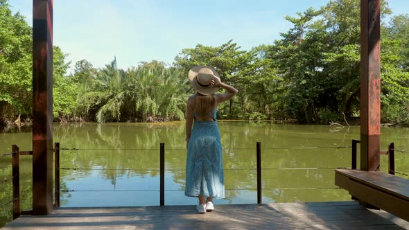 Back View of Travel Woman in City Park Enjoy Nature and View on Green Lake