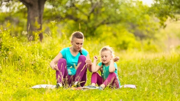 Mother With Daughter Sit On Nature