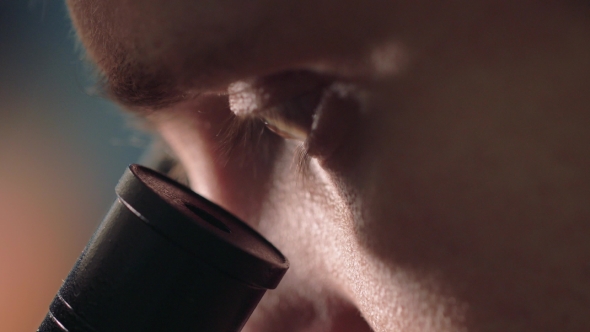 Scientist Looking Through a Microscope In a Laboratory. Young Doctror Diagnostic  Shot alt