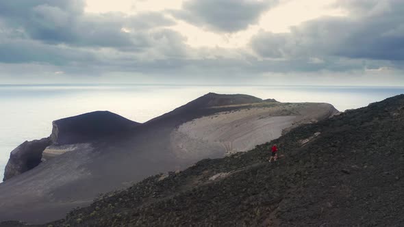 Caucasian Man Running Across a Volcanic Formation