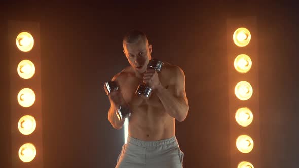 Male Boxer Punching To Camera and Aside Shirtless Athletic Man Boxing with Dumbbells on Smoky