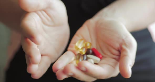 Close-up of Female Hands, Someone Pours a Bunch of Prescription Opiate Pills Into the Hand. Concept