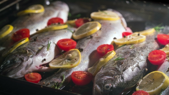 Delicious Trout Fish Is Baking In The Oven With Lemon, Tomatoes And Spices