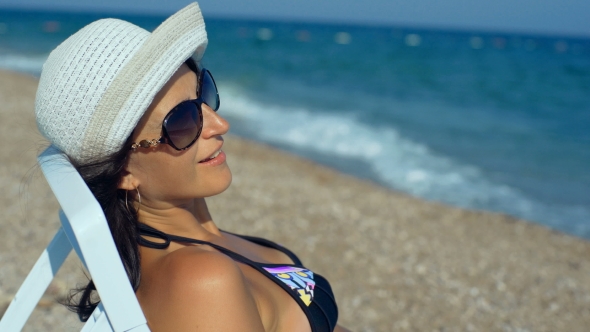 Young Woman Lying On Sunbed, Relaxing And Enjoying During Summer Vacation On Beach.